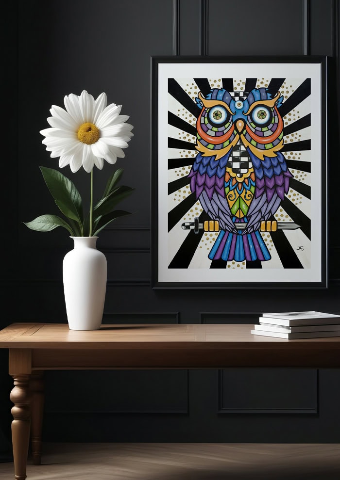 Owl print framed and hung on wall above table with daisy.